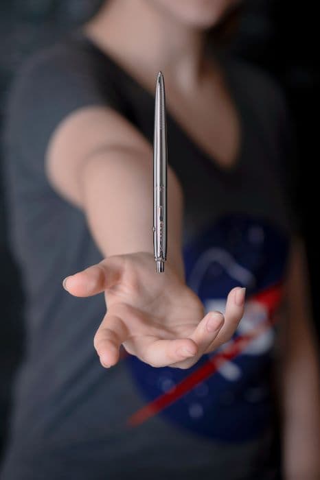 Chrome AG7 Original Astronaut Space Pen appears to float over an outstretched hand.